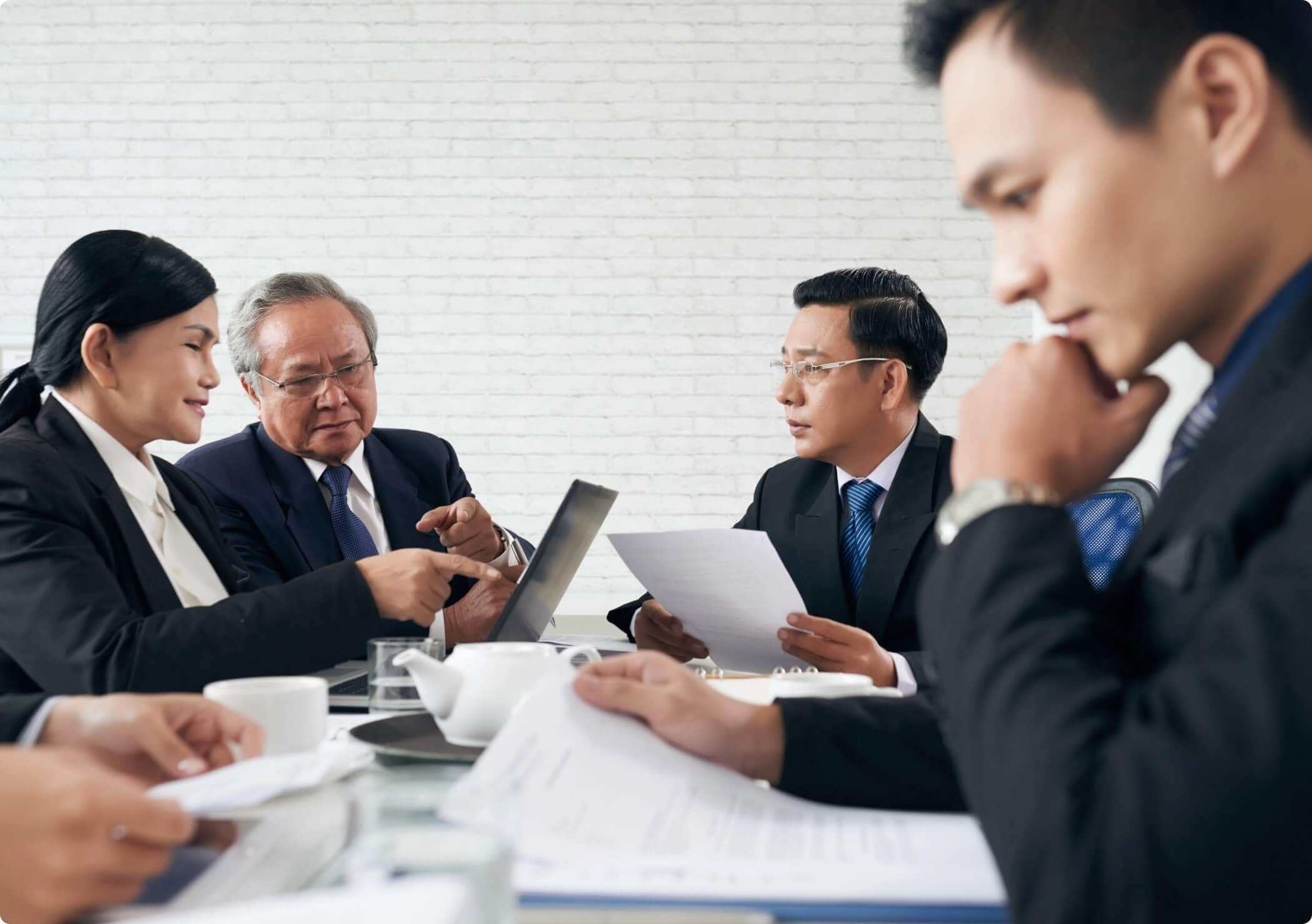 man looking intently and documents while having meeting