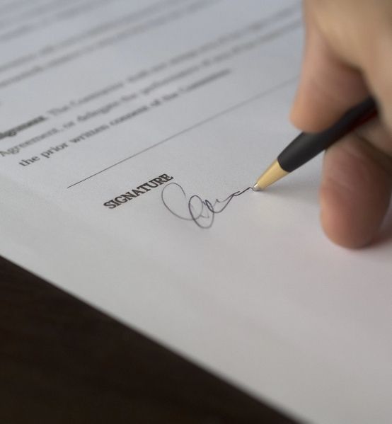man writing his signature on conveyancing contract lawyers