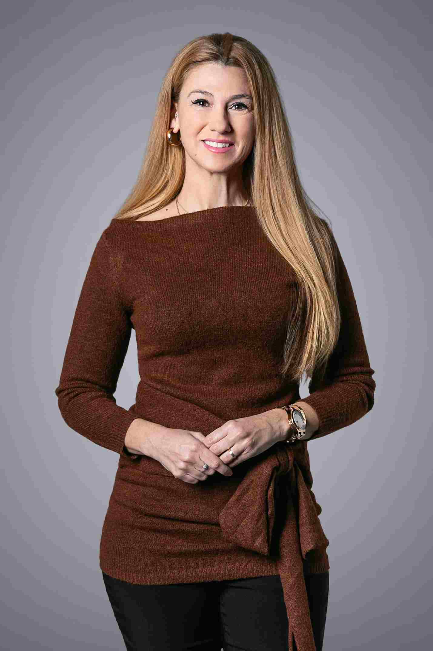 Woman in brown sweater, stylish pose.